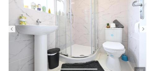 a bathroom with a shower and a toilet and a sink at The Stadium Rooms Elegant and Comfy Stay in London