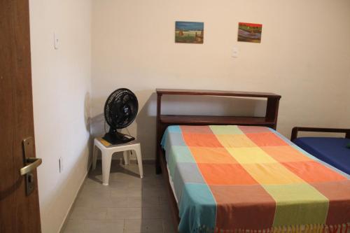 - une chambre avec un lit et une table avec un ventilateur dans l'établissement Azular Ubatuba - Eco Vila, Casas, Bangalôs, Yoga & Surf Inn, à Ubatuba