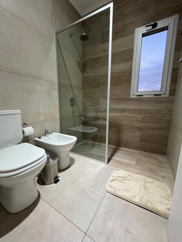 a bathroom with a toilet and a shower and a sink at Casa Quinta in Chivilcoy
