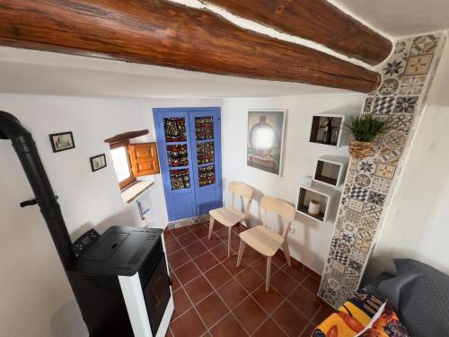 Cette chambre dispose d'une porte bleue, d'une table et de chaises. dans l'établissement Pequeña África en El Gastor, à El Gastor