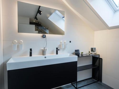 a bathroom with a white sink and a mirror at Waldklang - Refugium Schwarzwald in Alpirsbach