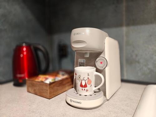 a coffee maker with a cup on top of a counter at Weranda in Bytom