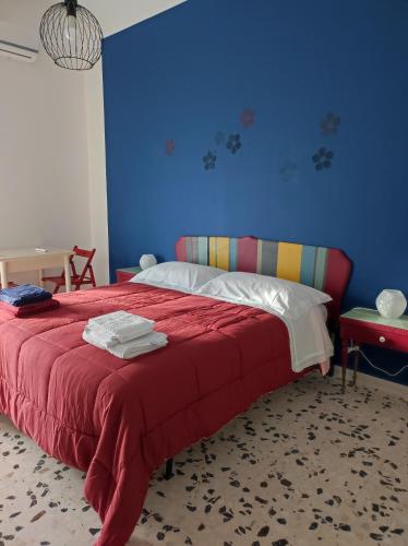 a bedroom with a red bed with a blue wall at Gli Amici di Filippo in Agira