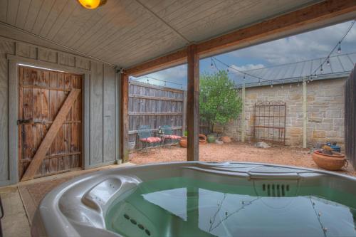 a bath tub in a room with a large window at New Pool, Hot Tub, Patio, Pickleball, Cornhole in Fredericksburg