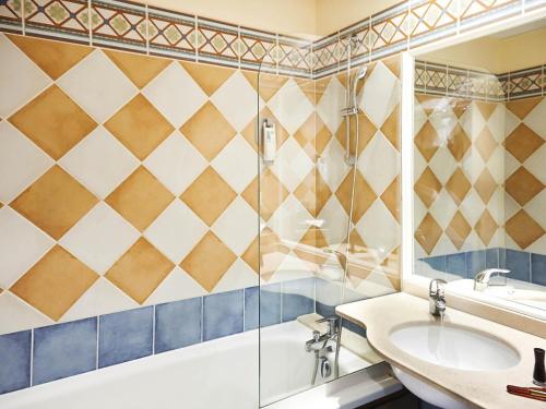 a bathroom with a tub and a sink and a shower at ibis Styles Arles Palais des Congrès in Arles