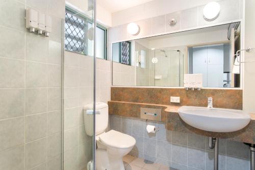 a bathroom with a toilet and a sink and a mirror at Capricorn Motel & Conference Centre in Rockhampton
