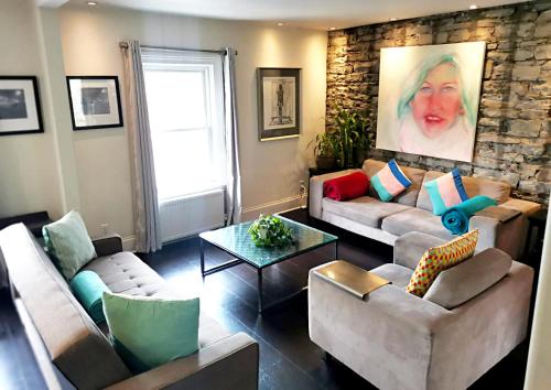 a living room with couches and a stone wall at KingstonStays Spacious Historic Downtown Stableman's House Loft in Kingston