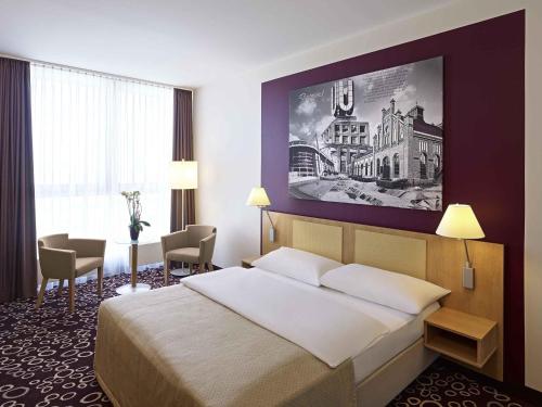 a hotel room with a bed and a large painting on the wall at Sunday Hotel Dortmund City in Dortmund