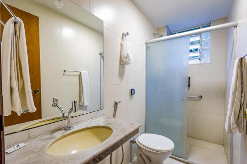 a bathroom with a sink and a toilet and a shower at Bevile Hotel in Cataguases