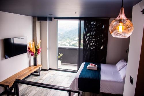 a bedroom with a bed and a large window at The Coffee Club Apartahotel in Manizales