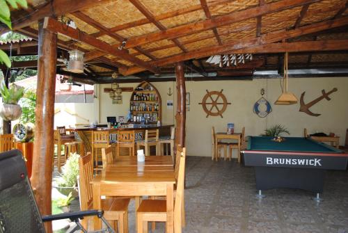 a restaurant with a pool table and a bar at Captain's Lodge and Bar in Panglao
