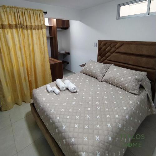 a bedroom with a bed with two towels on it at Italos Home Apartamentos en Popayán in Popayan