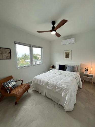 a white bedroom with a bed and a ceiling fan at Casa Alta PR in Santa Maria