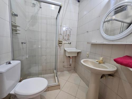 a white bathroom with a toilet and a sink at A uma quadra da praia de Copacabana in Rio de Janeiro