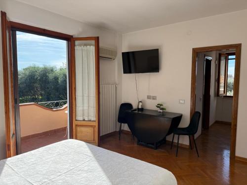 a bedroom with a bed and a desk and a television at Joe's apartments in Carrara