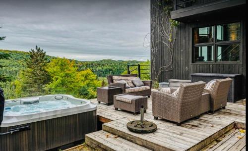 a hot tub on the deck of a house at Vue panoramique Spa Moderne in Sainte-Lucie-de-Doncaster