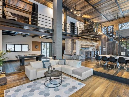 a living room with a couch and a table at Vue panoramique Spa Moderne in Sainte-Lucie-de-Doncaster