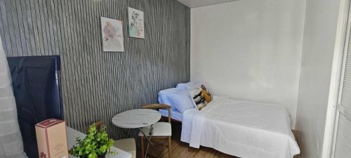 ein Zimmer mit einem Bett und einem Tisch darin in der Unterkunft Cozy room right in the heart of the city, close to everything you need in Davao City