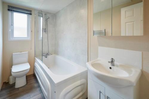 Barmby on the MoorにあるLucas Lodge with Hot Tubの洗面台とトイレを備えた白いバスルーム