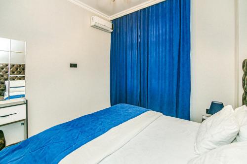 een slaapkamer met een bed en een blauw gordijn bij VIP Apartment LEOPARD in Baku
