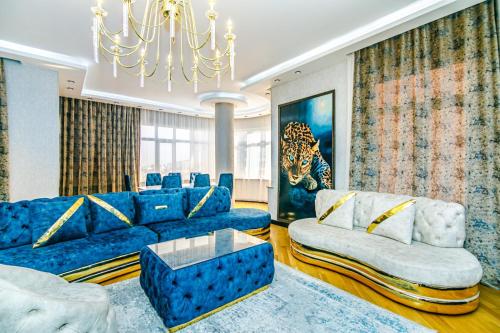 VIP Apartment LEOPARD في باكو: غرفة معيشة بأثاث أزرق وثريا