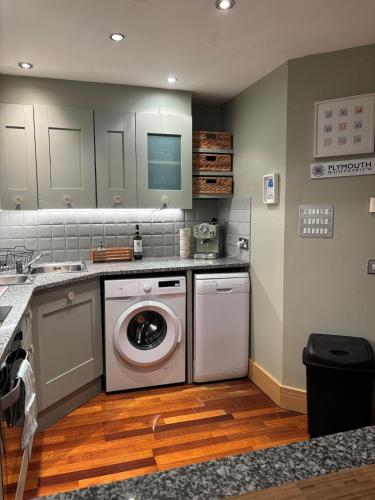 a kitchen with a washing machine and a dishwasher at Central Plymouth Sea View Penthouse Apartment with Secure Parking in Plymouth