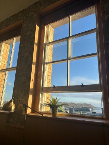 a window with a potted plant sitting in a window sill at Central Plymouth Sea View Penthouse Apartment with Secure Parking in Plymouth