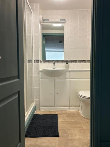 a bathroom with a sink and a toilet and a mirror at Central Plymouth Sea View Penthouse Apartment with Secure Parking in Plymouth