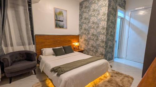 a bedroom with a large bed and a chair at Mileleishome in Buwate