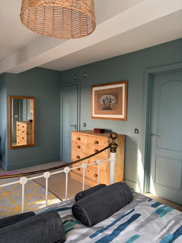 a bedroom with a bed and a blue wall at Central Plymouth Sea View Penthouse Apartment with Secure Parking in Plymouth
