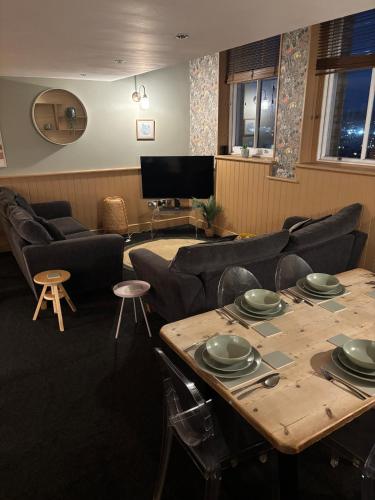 a waiting room with tables and chairs and a television at Central Plymouth Sea View Penthouse Apartment with Secure Parking in Plymouth