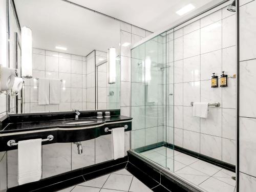 a bathroom with a sink and a glass shower at Novotel Sao Paulo Center Norte in Sao Paulo