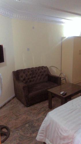 een woonkamer met een bank en een tafel bij Noblite suites in Gwarinpa