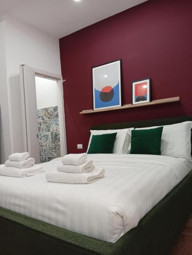 1 dormitorio con 1 cama blanca grande y pared roja en Prestige Apartment Leone, en Roma