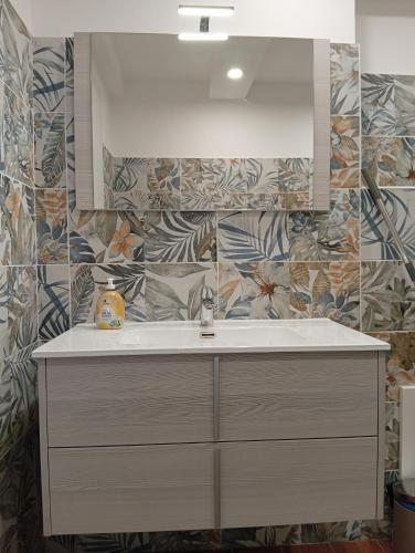 baño con lavabo y pared de azulejos en Prestige Apartment Leone, en Roma