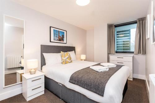 a bedroom with a large bed and a mirror at Central Modern 2BR Flat with Parking & Balcony in Liverpool