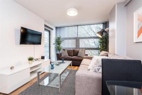 a living room with a couch and a table at Central Modern 2BR Flat with Parking & Balcony in Liverpool