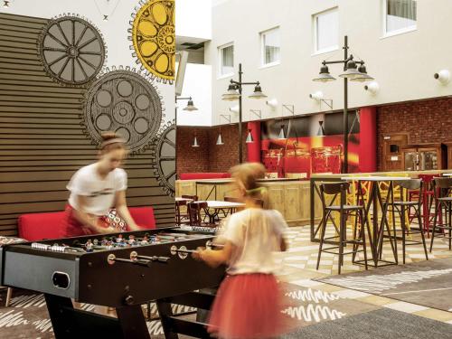 a couple of people playing a game on a table at Hotel Ibis Łódź Centrum in Łódź