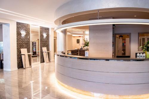 a lobby with a circular counter in a building at Hotel Olimpia in Imola