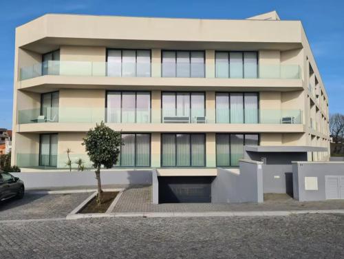 ein Gebäude mit einem Baum davor in der Unterkunft Horizonte do Mar in Apúlia