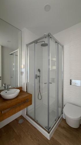 a bathroom with a shower and a sink and a toilet at Horizonte do Mar in Apúlia