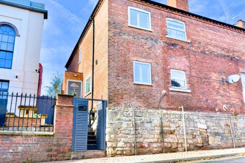 a brick building with a gate and a fence at Central, dog friendly, private courtyard in Edwinstowe