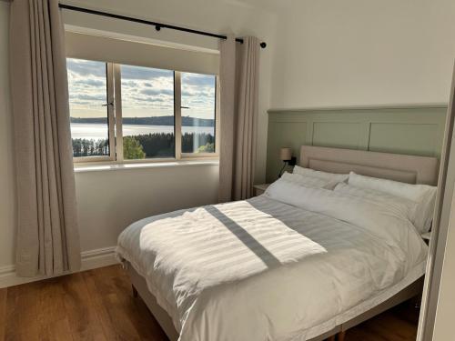 a bedroom with a large bed with a window at An Chill Bheag At the Blessington Lakes in Blessington