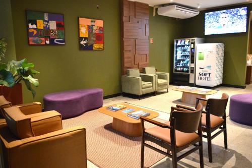 una sala de espera con mesas y sillas y un refresco en Belém Soft Hotel, en Belém