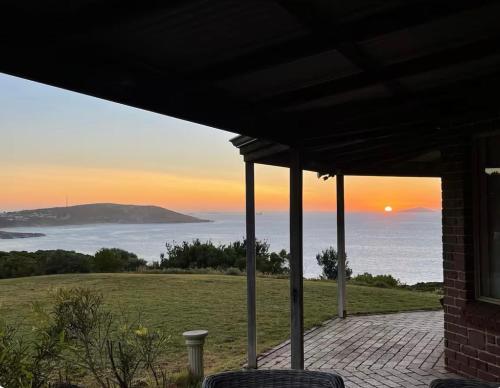 a house with a view of the ocean at sunset at Blue Haven Beach House - Guest Suite I 