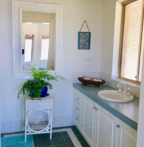 a bathroom with a sink and a mirror at Blue Haven Beach House - Guest Suite I