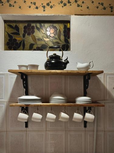 a shelf with a tea pot and cups on it at Casa Amaru Rooms in Guarne