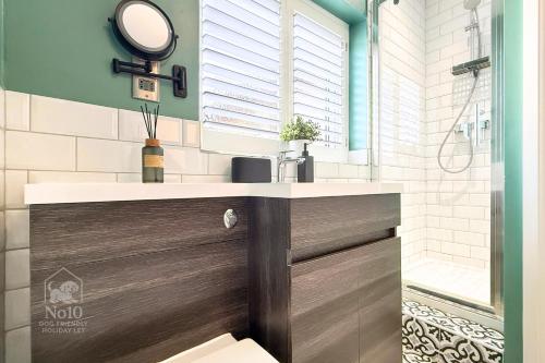 ein Badezimmer mit Waschbecken und Spiegel in der Unterkunft Central, dog friendly, private courtyard in Edwinstowe