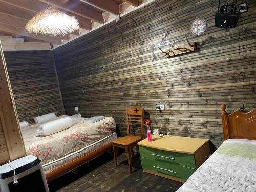 a bedroom with two beds and a wooden wall at Ohel in Mullini i Danit