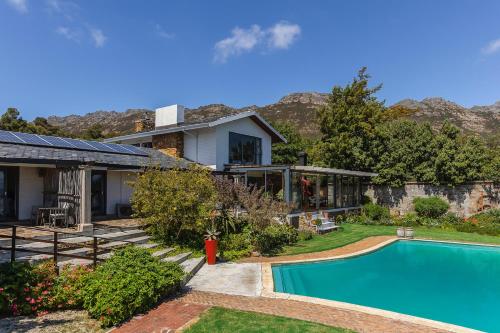 a house with a swimming pool in the yard at Watermill Studios in Gordonʼs Bay